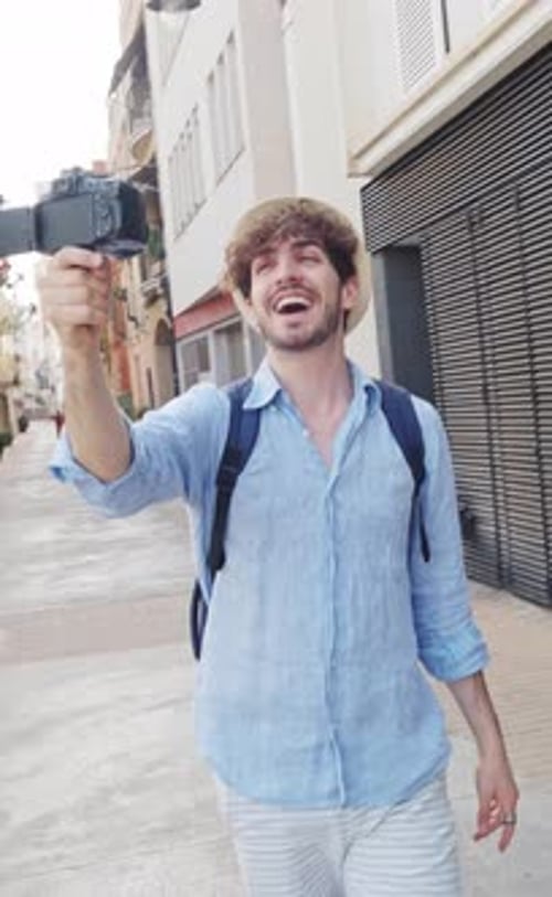 Man Vlogging while Walking in a City