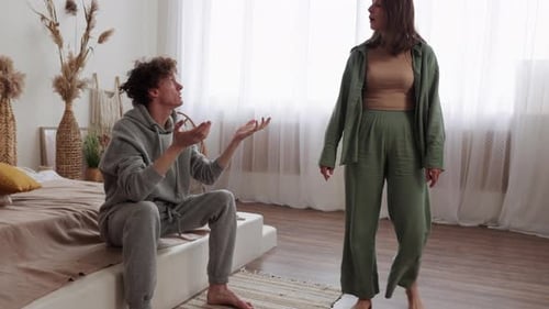 Couple Arguing Emotionally in Bedroom Displaying Tension in Their Relationship