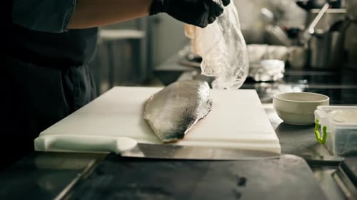 Professional kitchen in the hotel restaurant a large fresh salmon carcass lies on a cutting board