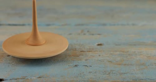 Wooden Toy Spinning Top on Blue Wooden Surface