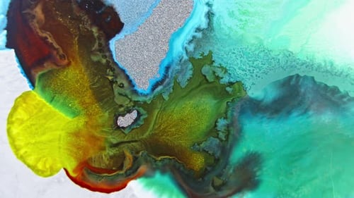 Close-up view of colorful ink in water with glitter, creating an abstract, organic pattern