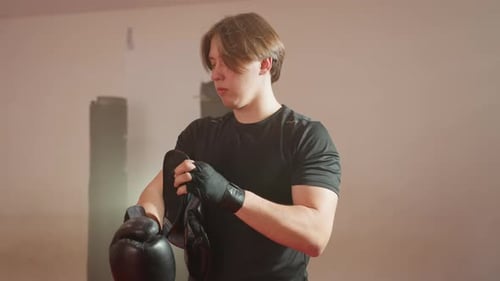 Man preparing for boxing match putting on gloves