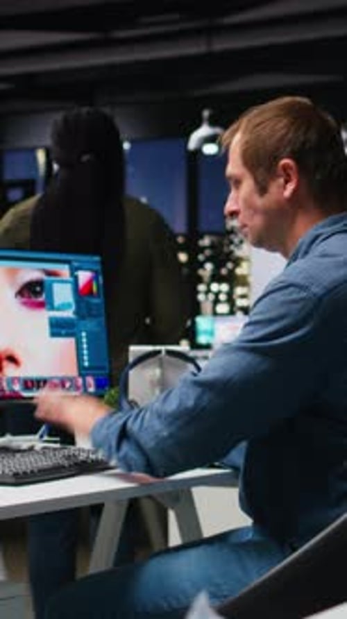 Man Works on Computer and Puts on Headphones