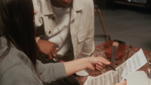 Musicians Collaborating on Sheet Music in Recording Studio