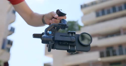Man Holding Gimbal With Phone in City Setting