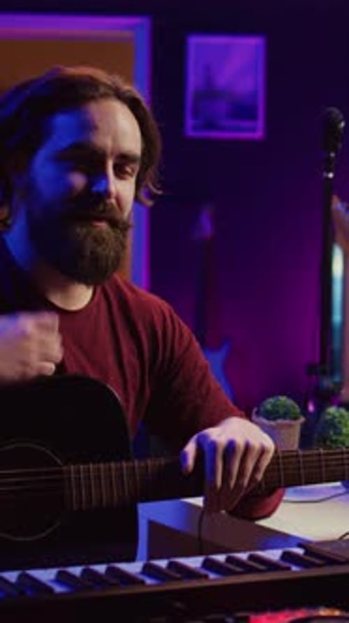 Man Plays Guitar at Music Studio at Night