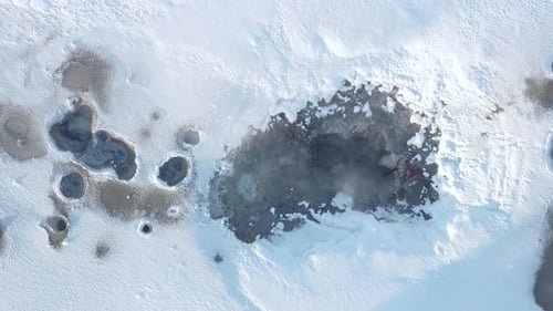 Aerial View of Geothermal Activity in Snowy Landscape