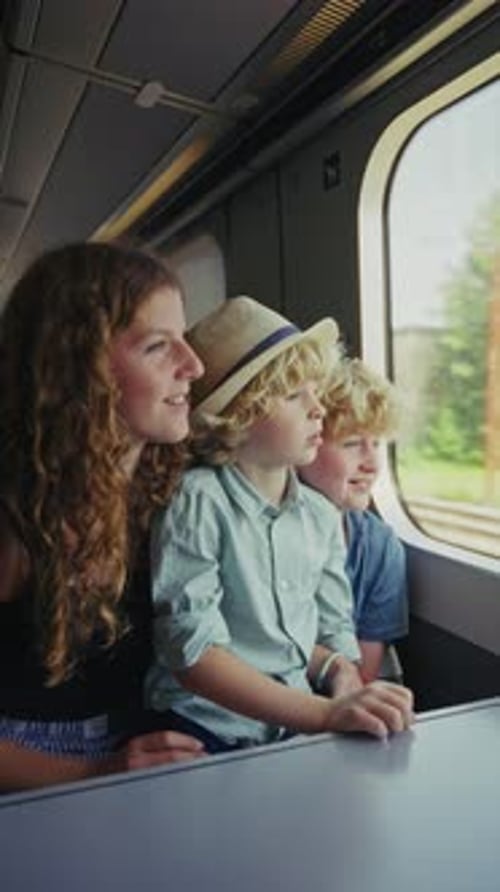 Niños mirando por la ventana del tren al pasar las vistas