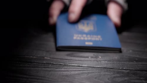 Close Up Shot of Person Identity Document Shot of Male Hand Placing Blue Ukrainian Passport with