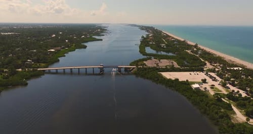 Flying Above A Canal With A Bridge And Ocean On The Right In Florida