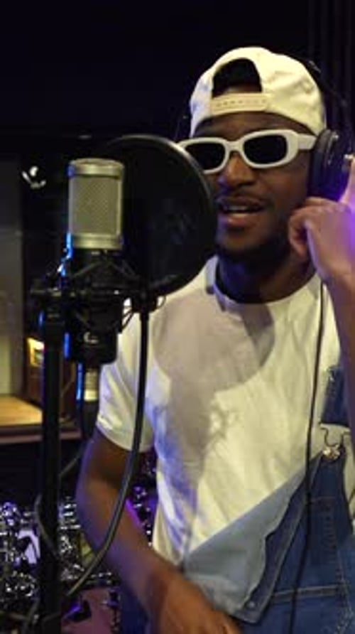 Young african american artist recording music in studio