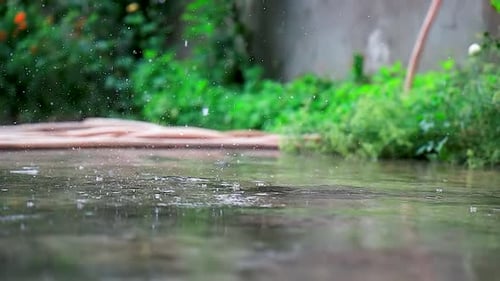 Beautiful rain drops hitting the ground in slow motion.