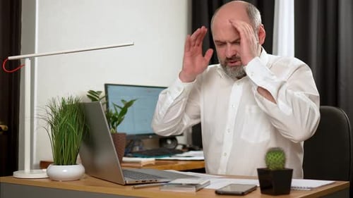 Stressed Businessman Working with Laptop and Calculator in Home Office Exhausted Ill Tired Middle