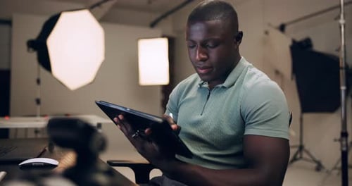Black man, photographer and production on tablet in studio for editing photoshoot pictures