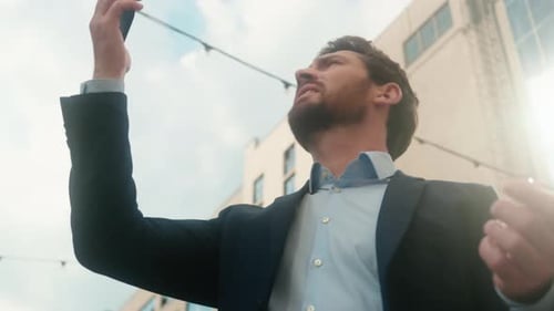 Young Adult Man Holding Phone Outdoors