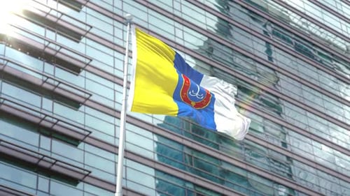 Waving Flag in Front of Modern Glass Building