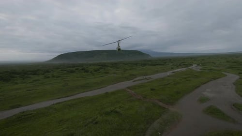 Helicopter Flying Over Green Valley Landscape