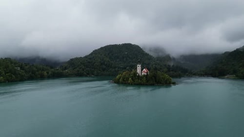 Lake Bled Slovenia push in drone aerial view cloudy background