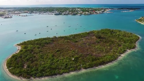 Sailboats gently resting near tropical island shore in the warm caribbean sunshine