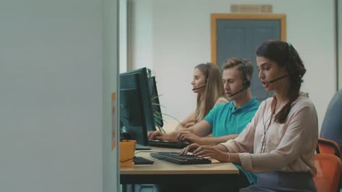 Professional Team Working at Call Center. Serious Workers in Headset Providing Information