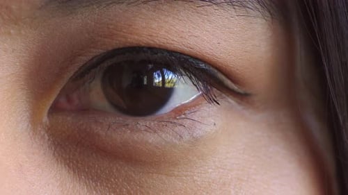 Nahaufnahme eines braunen Auges, das während eines Sehtests blinzelt