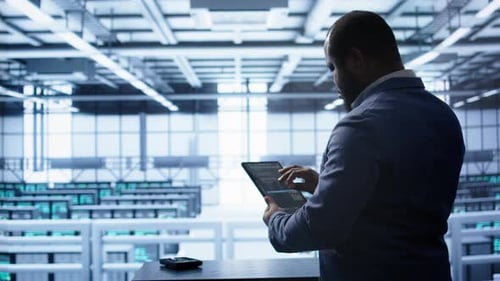 IT Expert in Data Center Holding Tablet Replacing Storage Mainframes Components