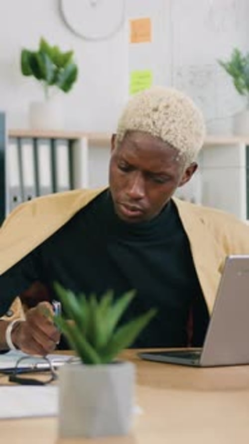 Workflow in Office Where African American Man in Stylish Wear Writing Important Notes in Papers and