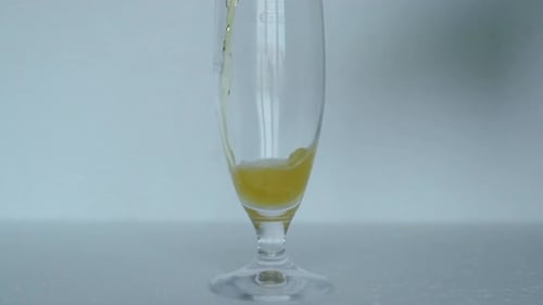 Pouring Refreshing Beer into Footed Glass