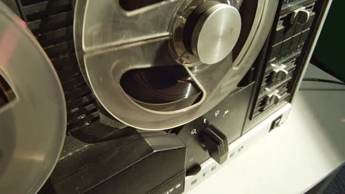Tape recorder started by hand, stopping and rewinding magnetic deck, closeup view