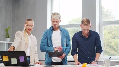 Team of Young Startupers is Working at the Table in the Office Discussing the Strategy and