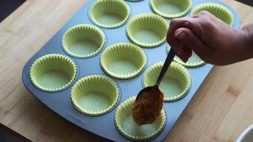Adding batter in baking pan for cupcake vegan pumpkin muffins using real roasted pumpkin in bowl hea