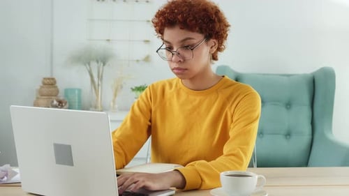 African American Girl Using Laptop at Home Office Looking at Screen Typing Chatting Reading Writing