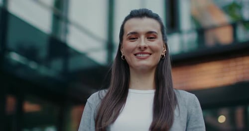 Satisfied Caucasian Girl Standing Outside in Front of Business Center Posing for Best View Looking