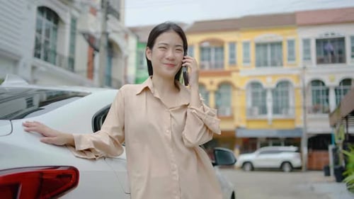 Smiling Woman Talking on Cell Phone by Car