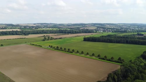 Rural landscape stretching into the distance with cultivated fields, forests, and a small village