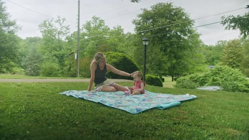 Mother and Infant Relaxing on Blanket in Yard