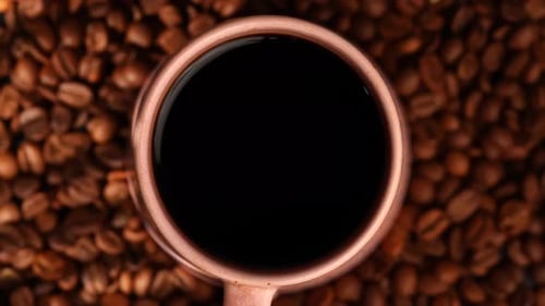 Top View Cup of Black Coffee Surrounded By Coffee Beans