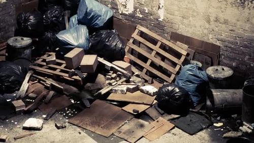 A Disordered Alleyway Filled with Garbage Bags and Debris in a City Setting