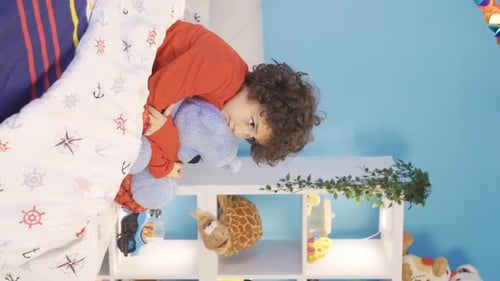 Cute Child Cuddling Teddy Bear in Bed