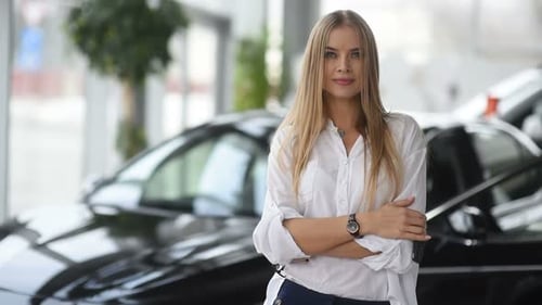 Woman in Car Showroom Holds Up Car Keys