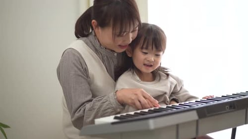 Woman and Child Play Electronic Keyboard Together