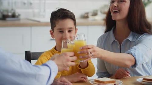 Family at Home Drinking Orange Juice Together