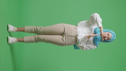 Full Body Of Asian Muslim Woman Looking At Camera And Showing Time Out Gesture In The Green Screen
