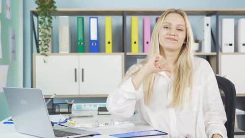 Woman Sits at Desk Talking to Camera