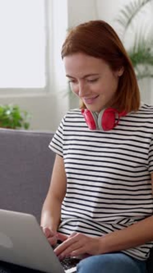 Young Adult Woman Using a Laptop Computer While Studying Online From Home