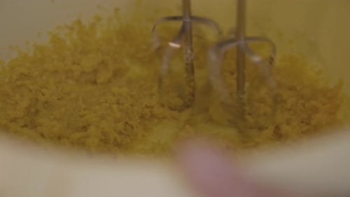 Mixing batter ingredients in bowl with hand mixer. Preparing cake. Closeup view