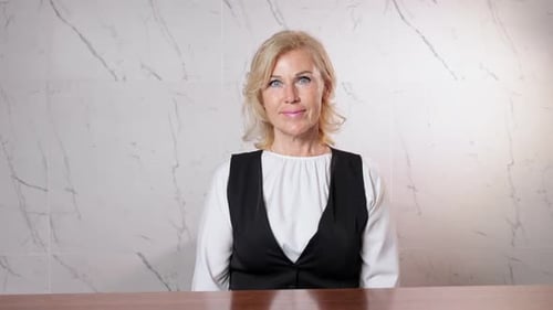 Blonde Receptionist at Reservation Table in Resort Hotel