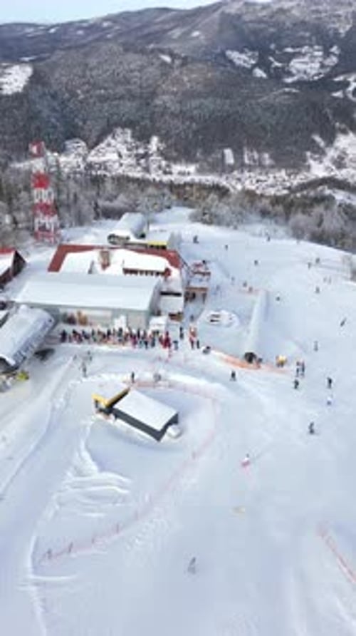 Aerial View of a Queue of People Waiting for a Chairlift at a Snowy Ski Slope
