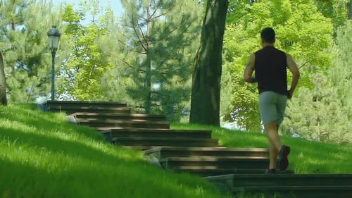 Man running up stairs in slow motion cardio workout in urban park