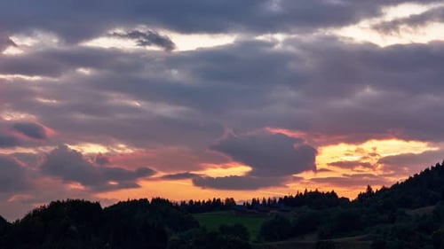 Nuages colorés et silhouette de forêtTimelapse